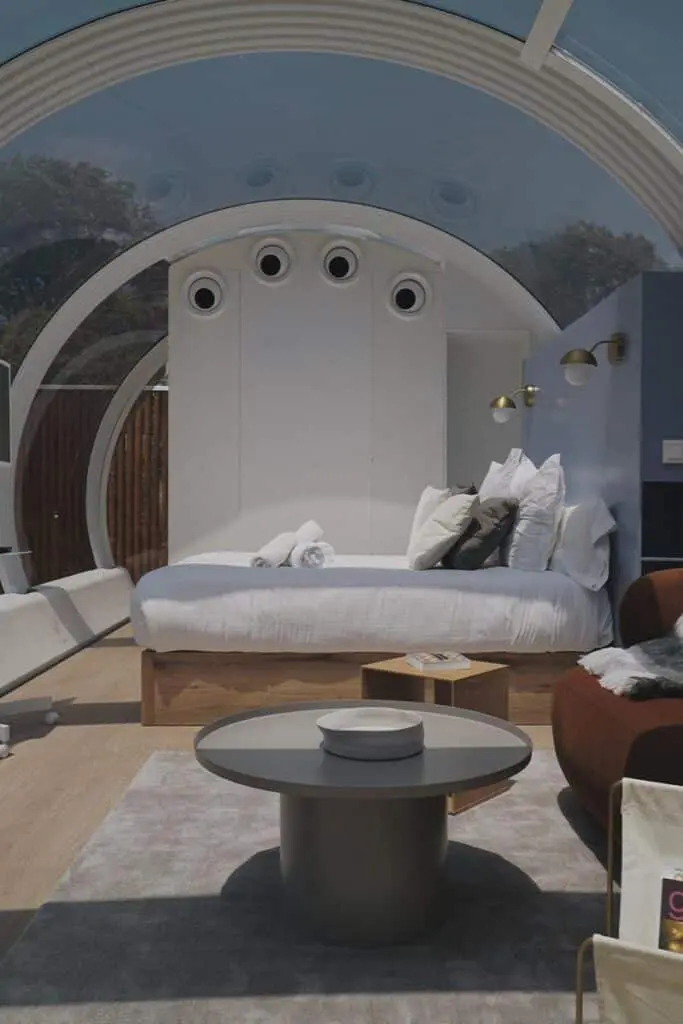 Modern bedroom with eco-friendly design and innovative circular window features, perfect for stylish, sustainable living.