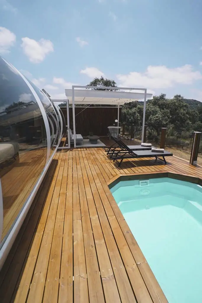Modern rooftop pool with wooden deck and lounge area at EJH Distribution.
