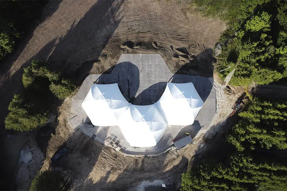 Modern warehouse construction with white tensile fabric structures affecting the building's aesthetic and function.