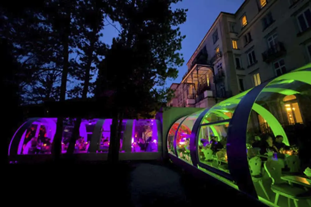 Colorful outdoor event tents with vibrant lighting at dusk, hosted by EJH Distribution.