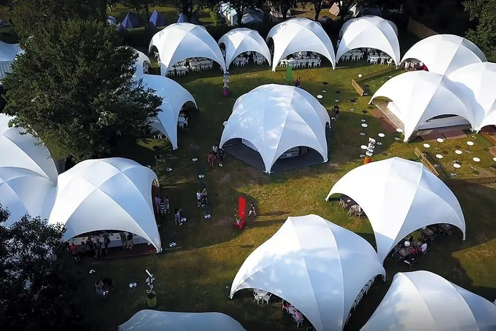Modern outdoor event tents with white canopy structures for special occasions and corporate events.