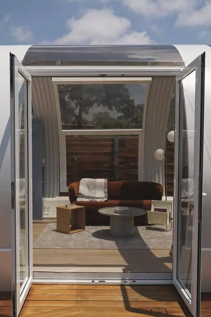 Modern outdoor patio enclosed space with glass doors, cozy seating, and contemporary decor.