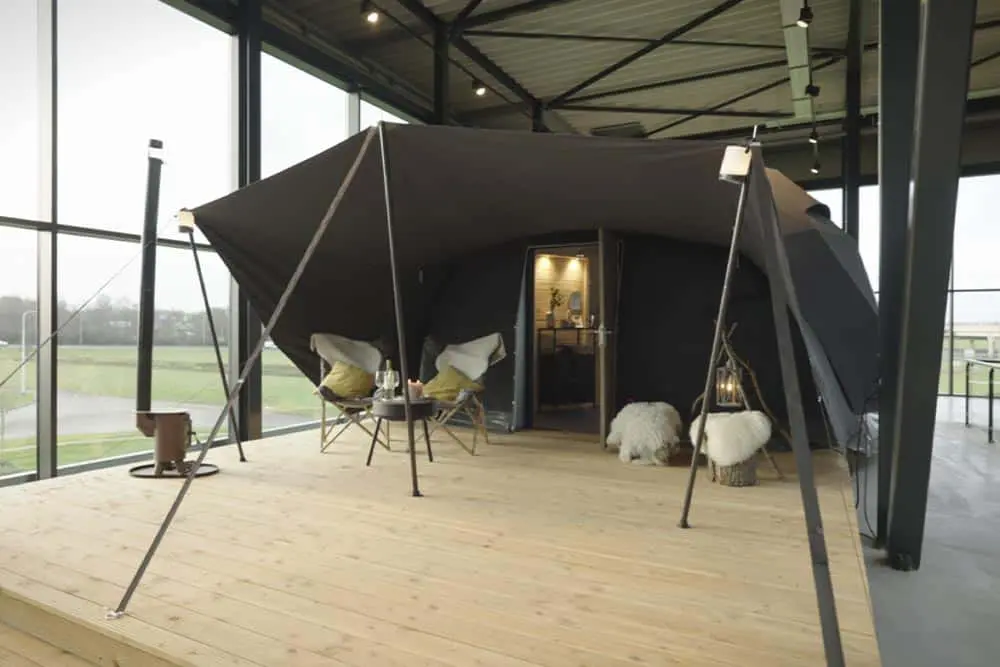 Modern luxury glamping tent setup with cozy furnishings and stylish decor for outdoor accommodation.