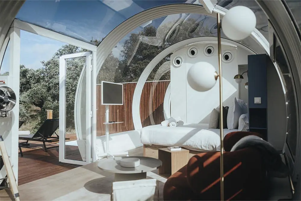 Cozy modern tiny home with glass dome and outdoor deck, stylish interior design.