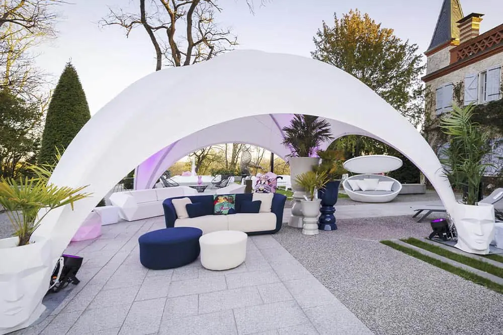 Elegant outdoor event setup with modern furniture and stylish lighting, perfect for upscale gatherings.