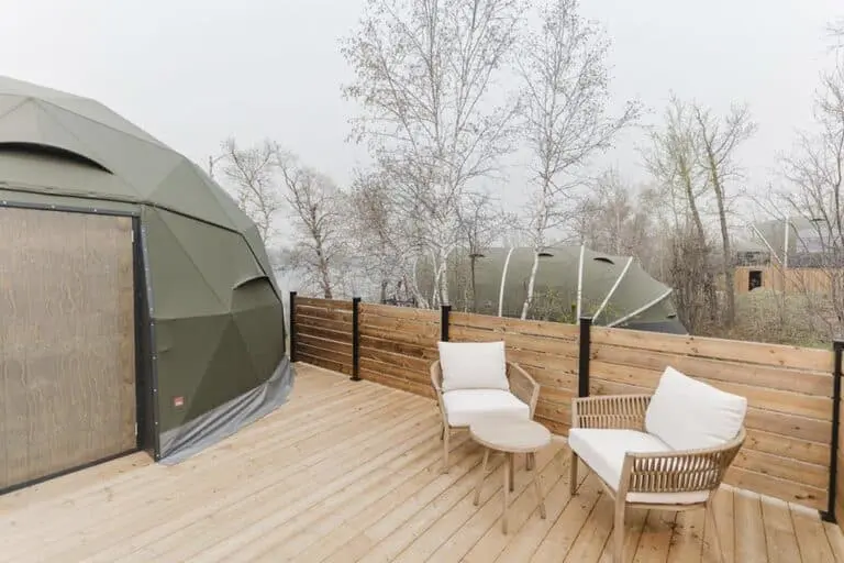 Eco-friendly geodesic domes on a wooden deck with outdoor seating, ideal for modern eco-lodges and sustainable outdoor accommodations.