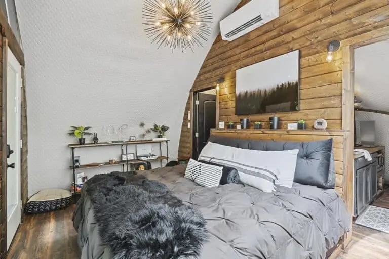 Stylish modern bedroom with wooden accent wall and cozy decor.