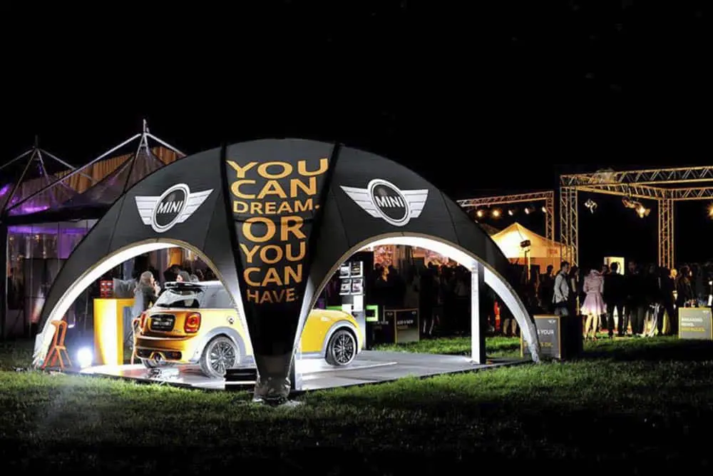 Mini car exhibit at a nighttime event by EJH Distribution, showcasing automotive promotional displays.
