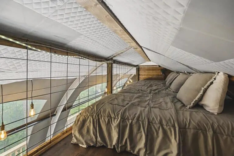 Ceiling loft bedroom with cozy bed and rustic wood accents, perfect for a charming home stay.