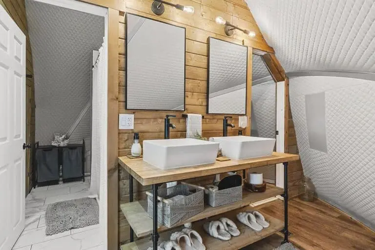 Elegant bathroom vanity with dual white vessel sinks and wooden accents, showcasing modern plumbing fixtures and decor.