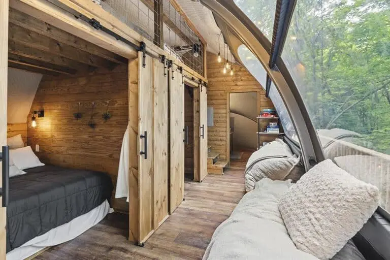 Cozy eco-friendly glamping pod with rustic wood interior and panoramic forest views.