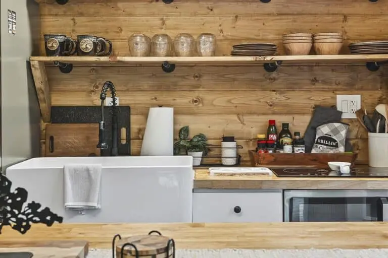 Rustic farmhouse kitchen with wooden shelves and modern appliances for home cooking and entertaining.