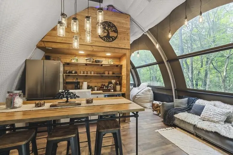 Cozy modern tiny house interior with kitchen, large windows, and wood accents for a relaxation retreat.