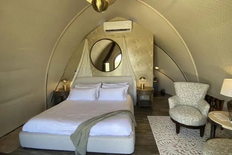 Luxury hotel bedroom with modern decor and cozy seating area.