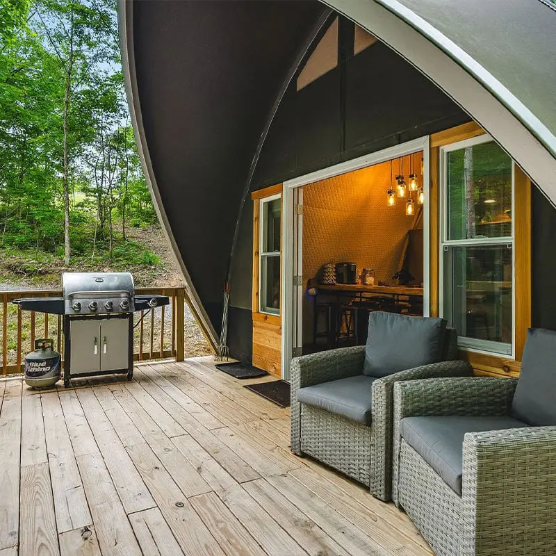 Outdoor yurt deck with grilling station and seating area for relaxation and entertainment.