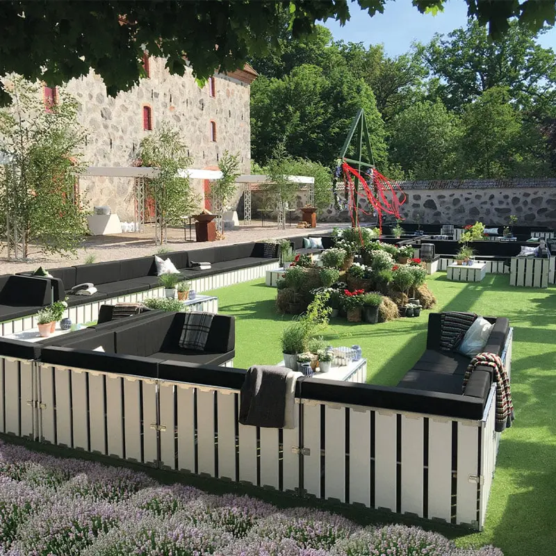 Stylish outdoor lounge area featuring modern furniture and lush greenery at EJH Distribution.