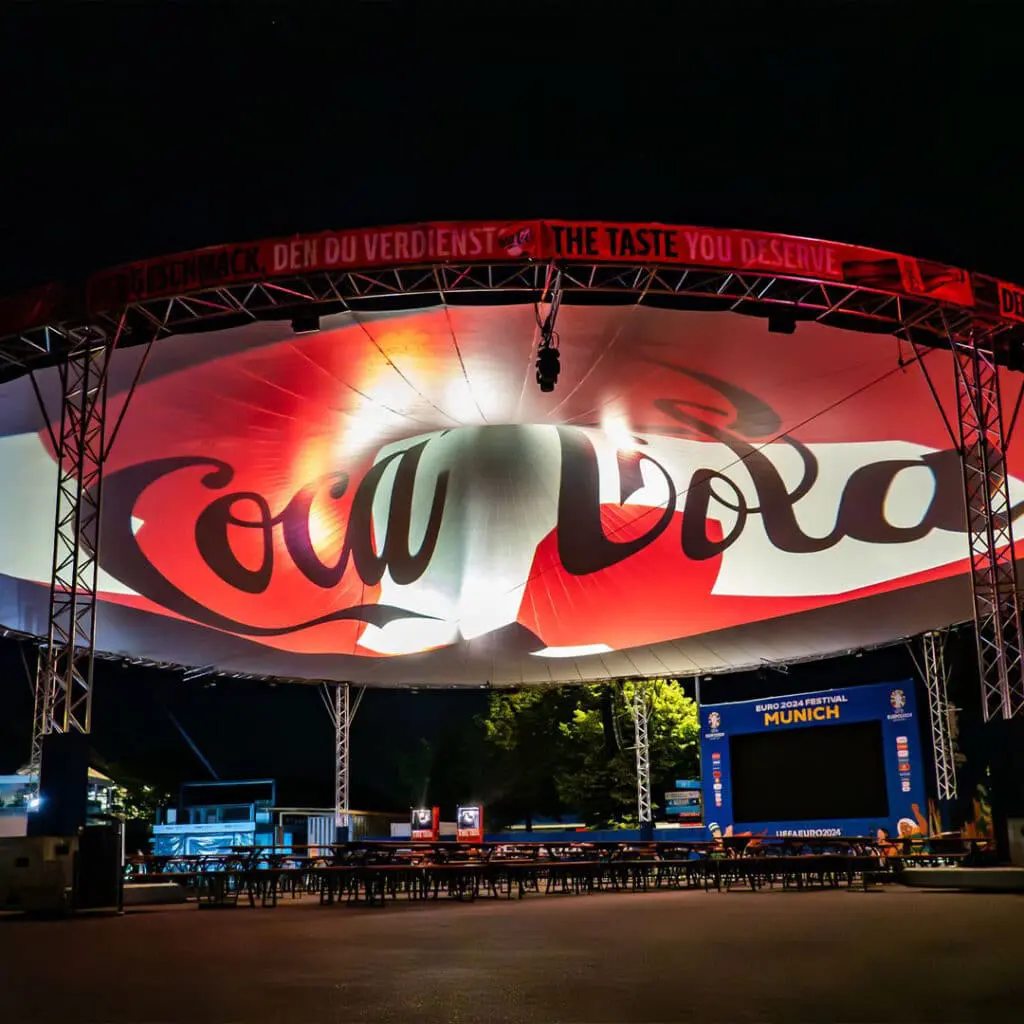 Coca-cola promotional event at Euro 2024 Munich, illuminated outdoor advertising display.