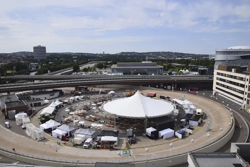 Large outdoor event setup with tents and equipment in an urban parking lot, showcase for event logistics and distribution services.