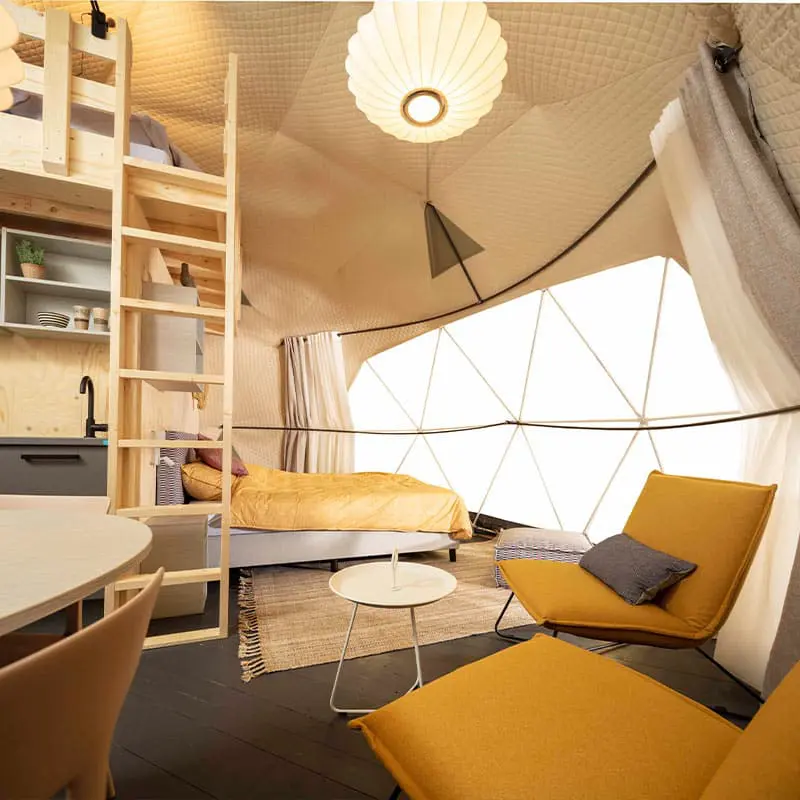 Cozy yurt interior with modern furniture and warm lighting, ideal for glamping or unique lodging experiences.