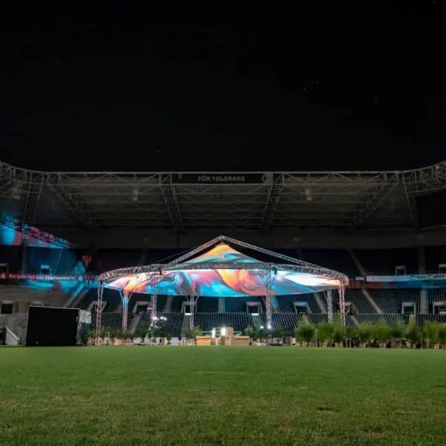 Colorful event stage setup at night in a stadium for concert or festival.