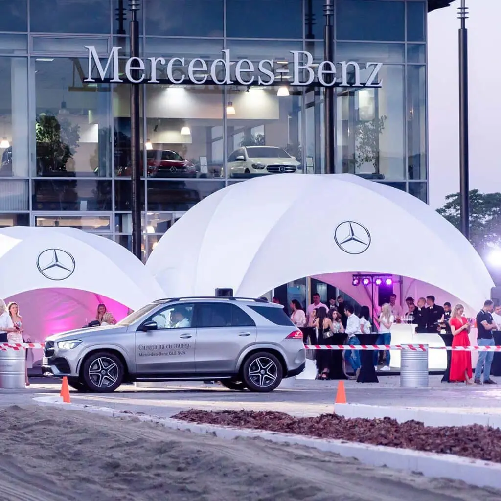 Luxury Mercedes-Benz SUV showcased at EJH Distribution event outside a Mercedes-Benz dealership, emphasizing premium automotive marketing.