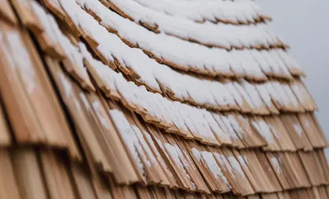 Wooden shingle roof covered with snow for winter weather protection.