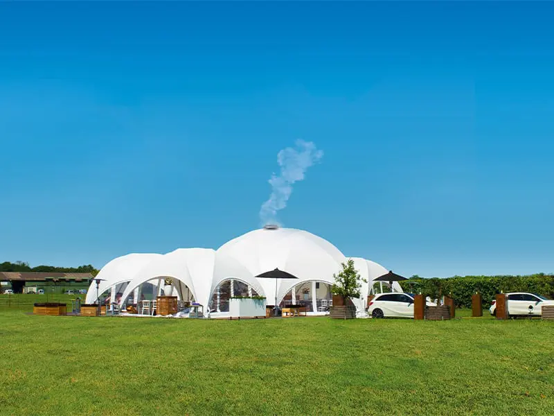 Futuristic event tent with white dome structure on green lawn, ideal for outdoor gatherings and special events.