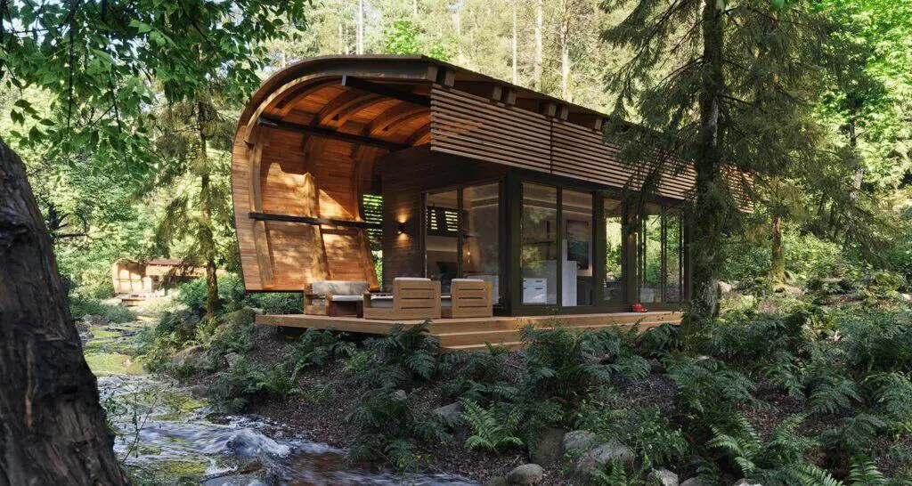 Modern eco-friendly tiny house with glass walls and wooden accents, nestled in lush forest scenery, perfect for sustainable living and nature retreat.