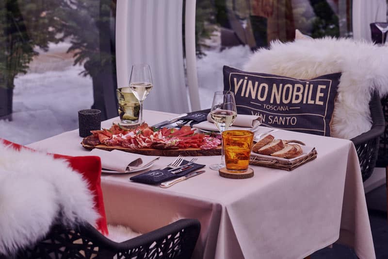 Perfectly set dining table with wine, charcuterie, and bread for an elegant meal.