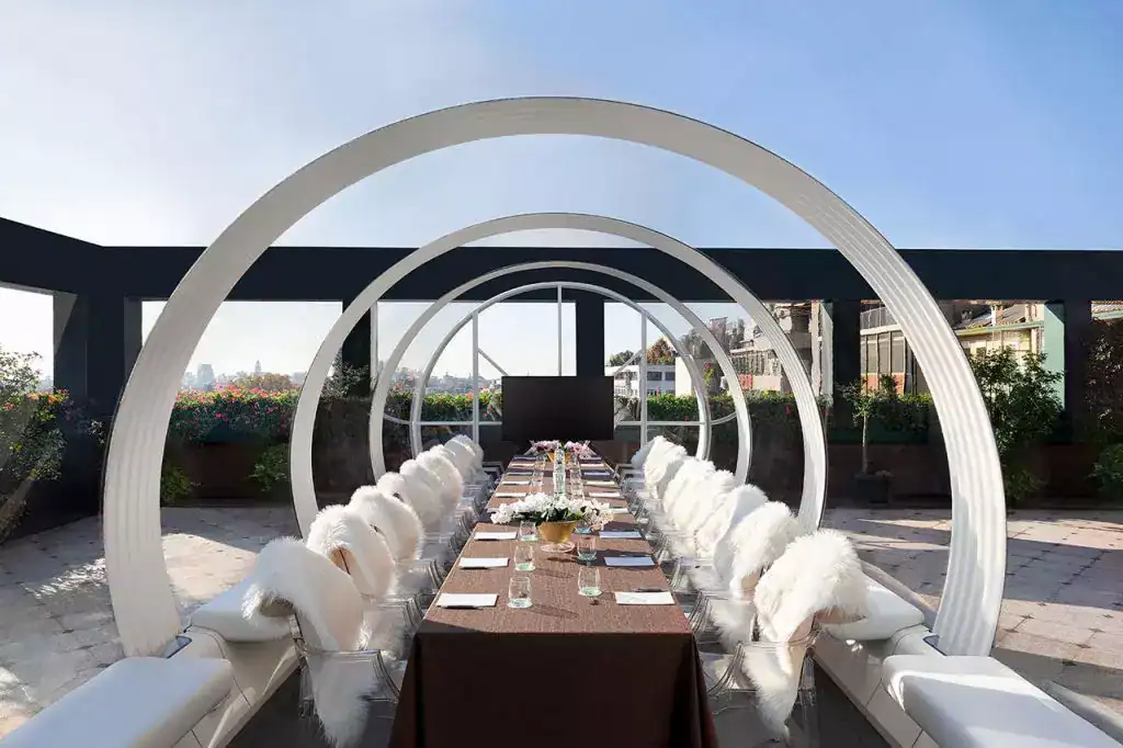 Elegant rooftop dining setup with modern circular arches for a luxurious event.